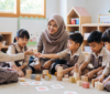 Guru mendampingi kegiatan sosial emosional anak TK dalam permainan kelompok